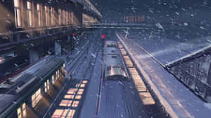 降雪覆蓋著一個寧靜的火車站夜晚，窗戶發光，火車靜止。