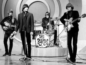 The Byrds 在舞台上現場演奏結他和鼓。