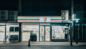 夜晚燈光明亮的7-Eleven商店，外面停著一輛單車。