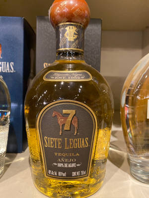 帶有馬標誌和金色標籤的 Siete Leguas Añejo 龍舌蘭酒瓶。