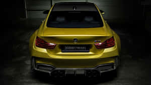光澤黃色改裝BMW M4跑車在黑暗車庫中的後視圖。