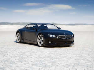 日落時分龜裂的沙漠地面上的黑色BMW跑車。