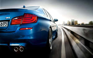 藍色BMW M5在高速公路上行駛，背景為城市天際線。