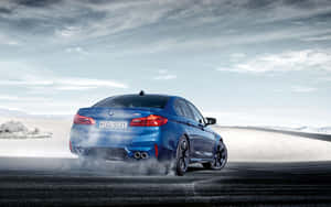 藍色BMW M5在沙漠道路上飄移，帶有煙霧