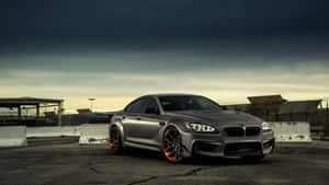 銀色BMW M6配橙色輪圈，黃昏時停泊在工業用地。 — 黃昏 壁紙