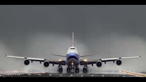 一架大型客機在暴風雨的天空下，降落在霧濛濛的跑道上。 — 飛機 壁紙