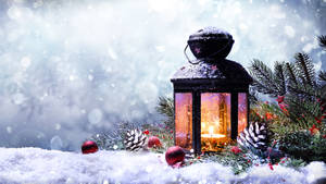 冬日降雪時，雪中點亮的燈籠，伴隨松樹和紅色裝飾品。