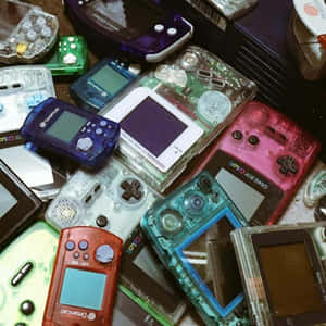 一堆色彩繽紛的復古手提遊戲機，如Game Boy Color和Dreamcast。