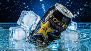 Rockstar Energy罐浸入水中，冰塊濺起水花。