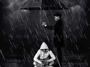 雨中兩個人，一個企喺度揸遮，一個蹲低