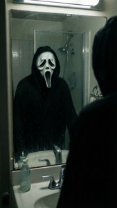 Ghostface面具反射在浴室鏡子中，背景有淋浴間。