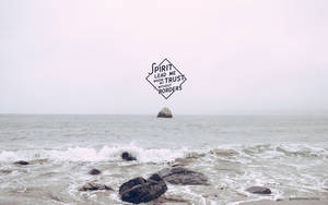 霧氣瀰漫的海洋，有海浪和岩石，並有一個漂浮的勵志標誌。