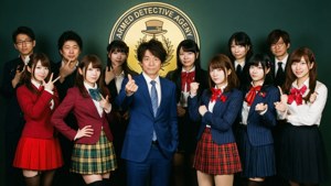 偵探動畫的演員穿著校服在機構標誌前擺姿勢。