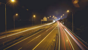 長時間曝光下車輛燈光軌跡的夜晚高速公路。