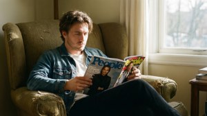 男子在窗邊的破舊扶手椅上閱讀《People》雜誌。
