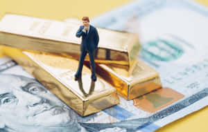 小型商人公仔站在放在美國美元鈔票上的金條上。