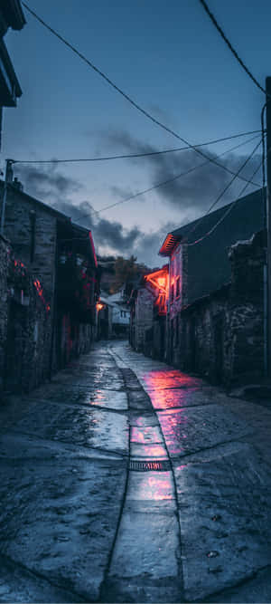 黃昏時分一條狹窄潮濕的石頭小巷，被紅色霓虹燈照亮。 — Pixel 10 Pro XL 壁紙