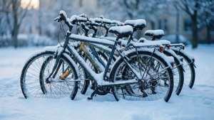 冬季公園暮色中停放的被雪覆蓋的單車。
