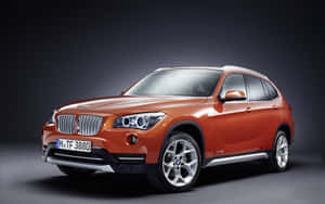 橙色BMW X1 SUV在工作室燈光下，深色背景。 — Steam Deck OLED 壁紙