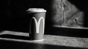 麥當勞咖啡杯，黑白，混凝土上有強烈陰影。