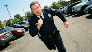 一名警察在陽光明媚的日子裡跑過停車場。