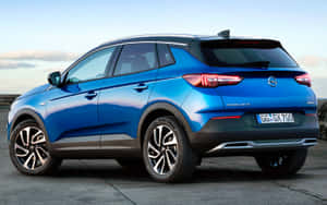 藍色Opel Grandland X SUV在陽光明媚的日子停放在戶外。 — Steam Deck OLED 壁紙