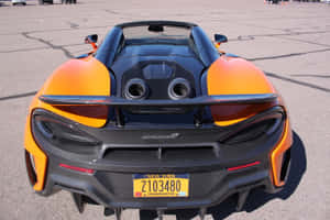橙色和黑色McLaren 600LT Spider，帶有紐約車牌，停在瀝青上。 — Surface Pro 壁紙