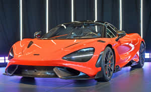 橙色McLaren跑車展示，帶有發光的燈光和後面的深色窗簾。 — Steam Deck OLED 壁紙