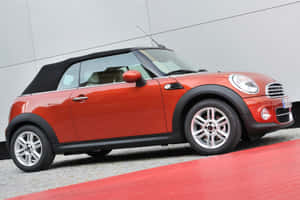 紅色MINI Cooper開篷車停在紅色地毯上，灰色牆壁。 — 酷車 壁紙