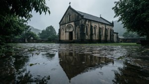淹水的庭院映照出灰濛濛雨天天空下的一座風化石頭教堂。