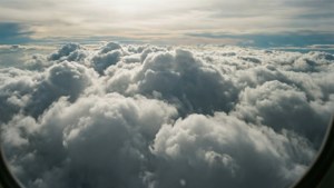 從飛機窗戶看到的蓬鬆白雲景色，上方金色天空