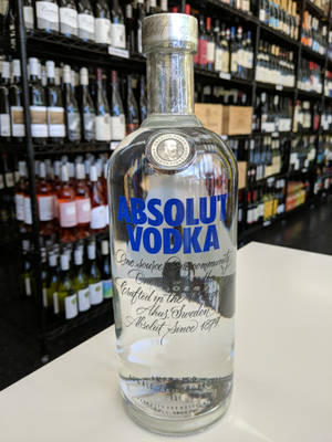 在酒類商店的白色櫃檯上的一個透明Absolut Vodka酒瓶。