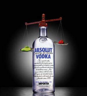 Absolut Vodka酒瓶與秤，上面有青檸和草莓，背景深色。