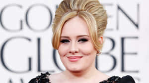 Adele 在金球獎上穿著黑色鑲飾連衣裙微笑。