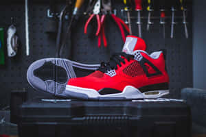 紅色Jordan 4波鞋放在車間工具箱上，牆上掛著工具。