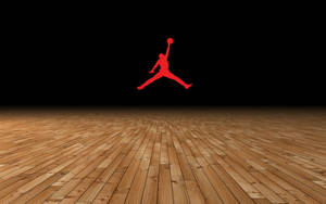 紅色Jordan標誌漂浮在木製籃球場上方，背景為黑色。 — Air Jordan GIF 壁紙