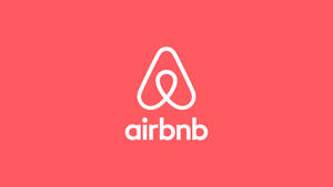 珊瑚粉紅色背景上的白色Airbnb標誌 — 粉紅 壁紙