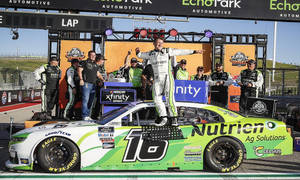 NASCAR車手在賽車上與車隊在賽道慶祝勝利。