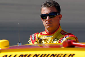 穿著賽車裝備的NASCAR車手從他的黃色賽車中探出身子。