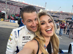 NASCAR車手和女子在賽車場活動中微笑