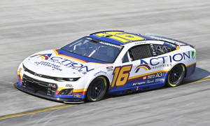 一架 #16 Action Industries NASCAR 賽車在賽道上高速行駛。