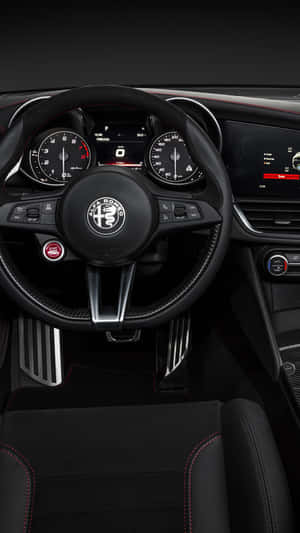 黑色 Alfa Romeo 跑車內飾，帶有紅色縫線和數碼顯示屏。