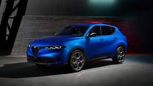 藍色 Alfa Romeo SUV 在攝影棚中，帶有戲劇性燈光和深色背景。