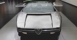 銀色 Alfa Romeo 概念車在博物館中展示，地板具有反射效果。