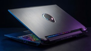Alienware遊戲筆記型電腦，配備彩虹背光鍵盤和拉絲金屬蓋上發光的外星人標誌。