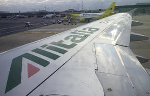 意大利航空飛機機翼在機場停機坪上，其他飛機和地面車輛。