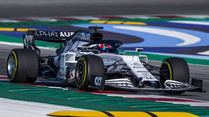 AlphaTauri F1賽車在色彩繽紛的賽道上比賽，車手清晰可見。