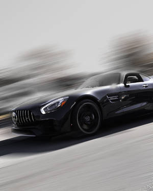 黑色Mercedes-AMG GT在模糊背景中疾馳。
