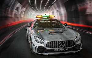 銀色 Mercedes-AMG FIA 安全車在隧道中高速行駛，燈光模糊。