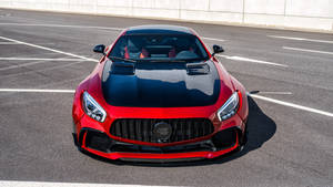 紅色 Mercedes-AMG GT R 跑車在明亮陽光下停放在瀝青路面上。